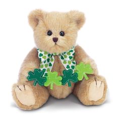 a brown teddy bear with green shamrocks on it's chest and legs sitting down