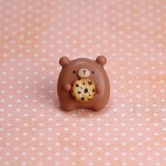 a chocolate bear with a cookie in it's mouth on a polka dot tablecloth