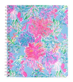 a spiral notebook with pink and blue flowers on it, in front of a light blue background