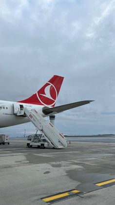 an airplane is parked on the tarmac with stairs leading up to it's door