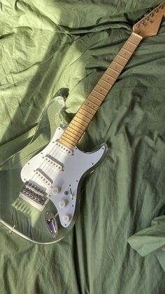 an electric guitar is laying on a green sheet