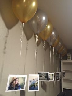 some balloons are hanging from the ceiling with pictures on them and one balloon is in the air