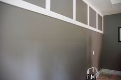 an empty room with gray walls and white trim on the bottom part of the wall