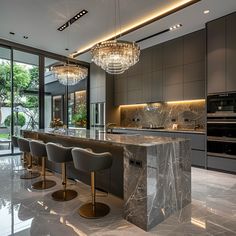 an elegant kitchen with marble counter tops and bar stools in front of large windows