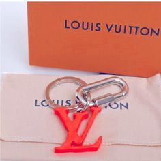 the louis vuitton keychain is red and has an orange v on it