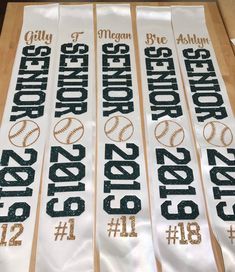 four white banners with gold numbers and baseballs on them, sitting on a table