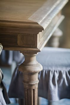 a close up of a wooden table with a cloth draped around the top and bottom