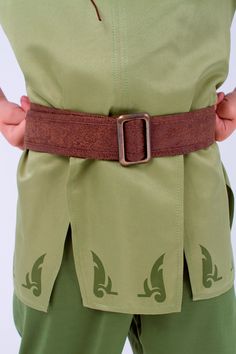 a person wearing green pants and a brown belt is standing with their hands on his hips