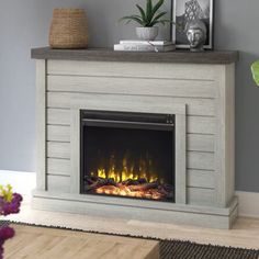 an electric fireplace in a living room next to a coffee table and potted plant