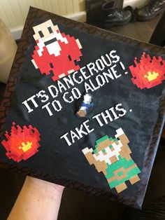 someone is holding up a graduation cap that says it's dangerous to go alone take this