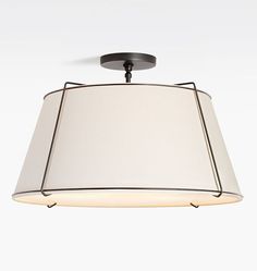 a light fixture with a white shade hanging from it's center point on the ceiling