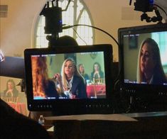 two televisions sitting next to each other in front of a cameraman's monitor