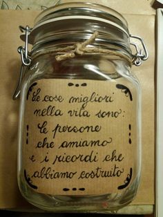 a glass jar with writing on it sitting in front of a wooden box filled with other items