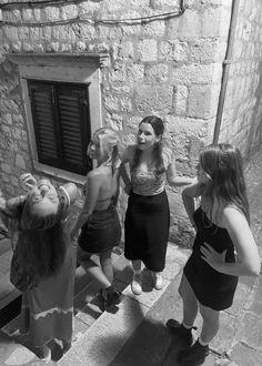 black and white photograph of three girls standing on steps