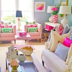 a living room filled with lots of furniture and colorful pillows on top of it's couches