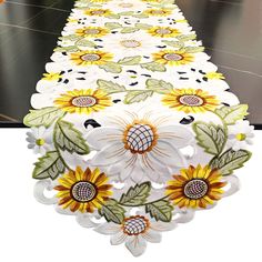 a long table with sunflowers and leaves on it