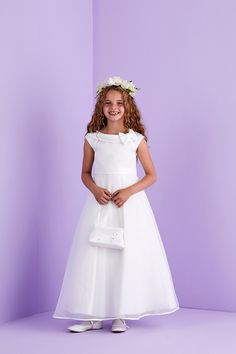 This is a stunning Ivory satin Holy Communion dress. A stylish ankle length first Holy Communion sleeveless dress. The duchess satin dress has a gorgeous shawl collar and bow attached at the side. The organza overlay skirt and raglan style capped sleeves compliment the style of this dress keeping it a clean cut style. Whilst at the back is a large pre tied bow with luxurious long tails completing the look and maintains a perfect bow each time you wear this dress. Fastened at the back with a hidd Duchess Satin Dress, Organza Overlay, Holy Communion Dresses, Perfect Bow, Overlay Skirt, Duchess Satin, Dress Flower, Capped Sleeves, Holy Communion