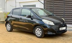 a small black car parked in front of a garage