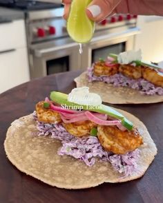 two tacos with meat and vegetables on them sitting on a table in a kitchen