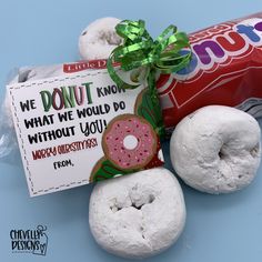 two donuts and a candy wrapper on a blue surface with a sign that says, we donut know what we would do without you happy christmas from