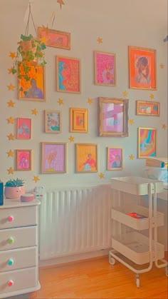 there are many framed pictures on the wall in this child's room, including princesses