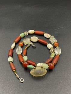 The origin of this beads from the central Asian country Afghanistan. The history of this beads is more than 2000 years old . many kingdoms passes through this countries of central Asian for example Greek roman Sasanian many others. they were used to be a jewelry ornaments and trade beads in ancient times . the necklace got white crystals and red agate and green color turquoise and got two Special small size white crystal tortoise and in the central one amulet type white crystal amulet bead we pr Vintage Jade Necklace With Natural Stones, Unique Gemstone Round Beads, Bohemian White Jade Necklaces, Unique Crystal Necklaces With Round Natural Stones, Unique Crystal Necklace With Round Natural Stones, Unique Crystal Necklace With Natural Stones, Unique Carnelian Jewelry With Colorful Beads, Amber Agate Jewelry With Colorful Beads, Artisan Crystal Necklace With Round Natural Stones