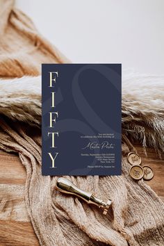 a wedding card with the word fifty on it and two gold rings next to it