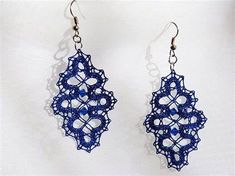 a pair of earrings with blue beads hanging from them