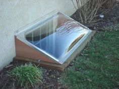 a small window sitting on the side of a building next to a grass covered yard