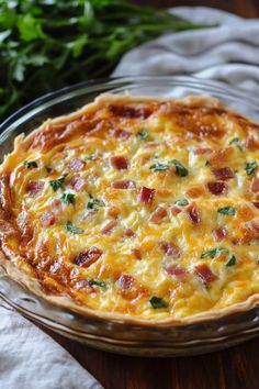 a cheesy quiche in a glass dish on a wooden table with parsley