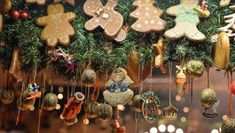 christmas cookies are hanging from the ceiling in front of a display case with ornaments on it