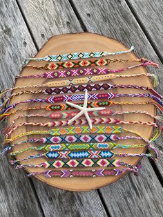 a wooden plate topped with lots of bracelets and a starfish on top of it