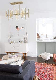 a living room filled with furniture and a chandelier hanging over the top of it