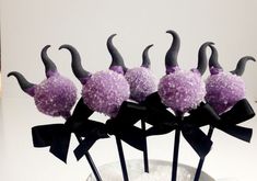 purple cake pops decorated with black horns and bowknots in a glass vase