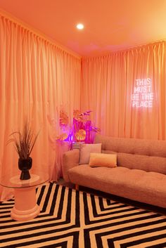 a living room with pink curtains and black and white striped rugs on the floor