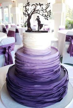 a wedding cake with purple ruffles and a silhouette of a bride and groom on top