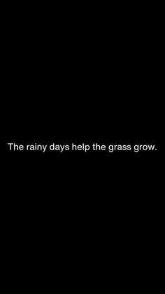 the rain days help the grass grow text on a black background with an orange umbrella