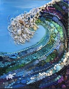 an art piece made out of buttons and other items on a blue surface with water in the background