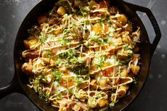 a skillet filled with food sitting on top of a black counter next to utensils