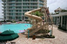 people are in the swimming pool at an apartment complex with a water slide and slides