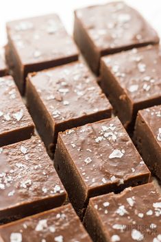 there are many pieces of brownies on the table together with white flecks