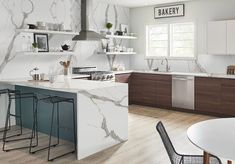 a kitchen with white marble counter tops and wooden flooring next to a dining room table