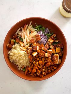 a bowl filled with rice, meat and veggies on top of a table