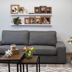 a living room filled with furniture and pictures hanging on the wall above it's coffee table