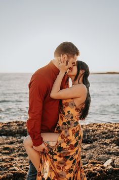 a man and woman kissing on the beach