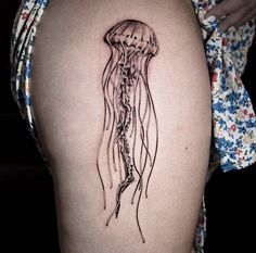 a woman's thigh with a jellyfish tattoo on it