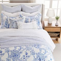 a bed with blue and white comforters in a bedroom