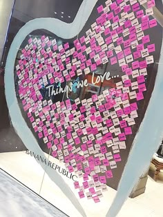 a heart shaped display with pink sticky notes on it