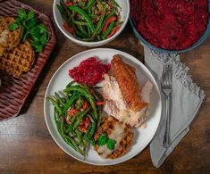 three plates of food on a table with silverware and utensils next to them