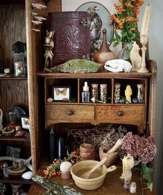 an old wooden cabinet filled with vases and other items on top of a table